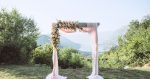 wedding arch outside with pink gauze and flowers
