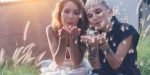 Two beautiful young girls woman bride, lesbian wedding, beauty fashion and rights lgbt concept, blow on a dandelion.