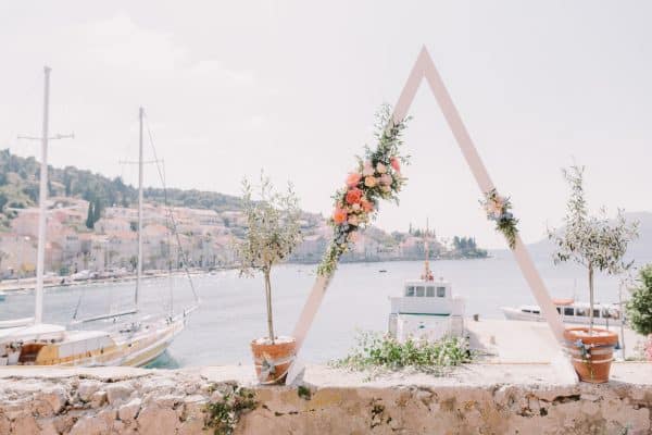 destination wedding triangle arch with sea view. Triangle wedding arch in Croatia. Destination wedding with unqiue flower arch.