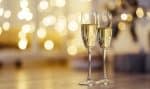 Lesbian wedding champagne flutes against a gold bokeh background