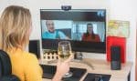 Young woman chatting with friends drinking wine and laughing together - Alternative party during home isolation quarantine - Focus on glass hand