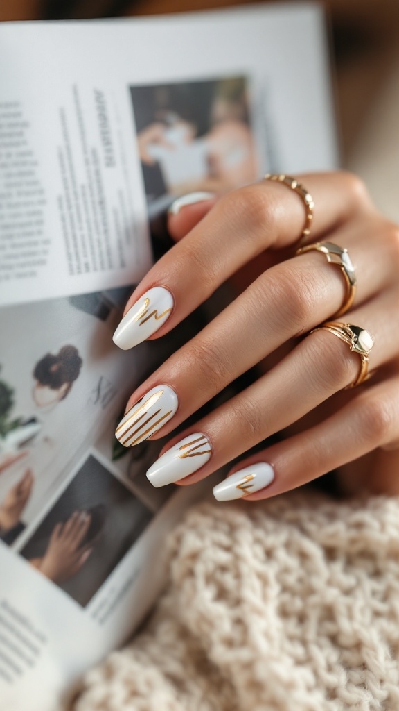A close-up of elegant gold and white striped wedding nails, complemented by delicate gold rings.