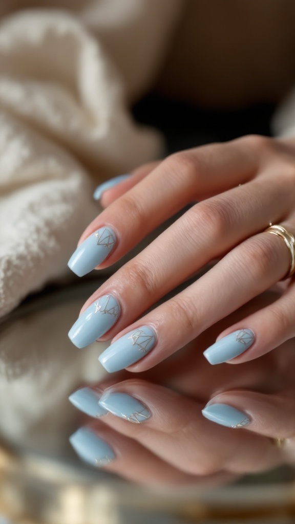 A close-up of light blue wedding nails with silver geometric designs.