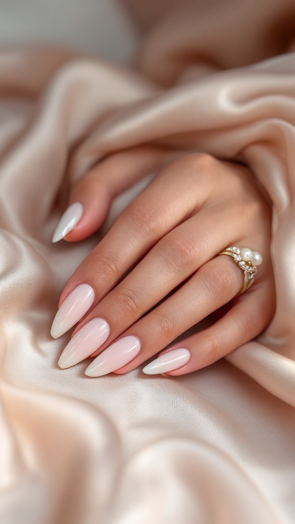 Bridal nails with a soft pink to white gradient, a matte finish, and pearl and rhinestone accents.