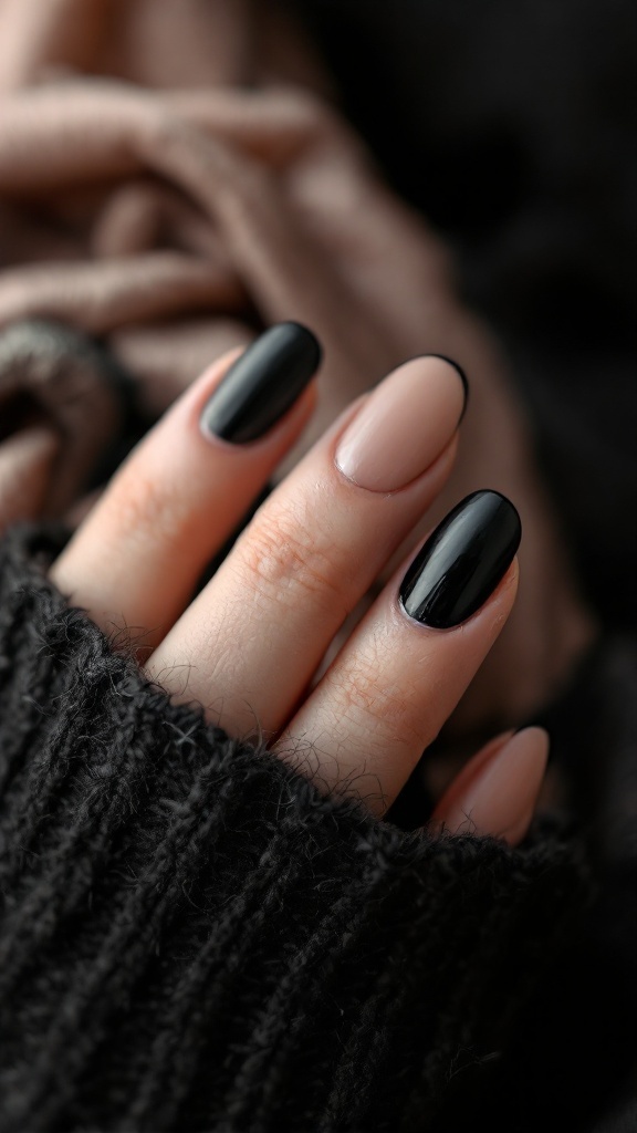 Close-up of matte black nails with shiny tips, set against a cozy fabric background.