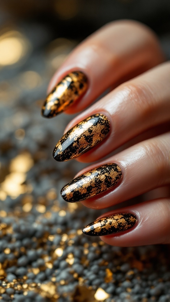 Close-up of nails with gold leaf embellishments on black polish, featuring stiletto shape.