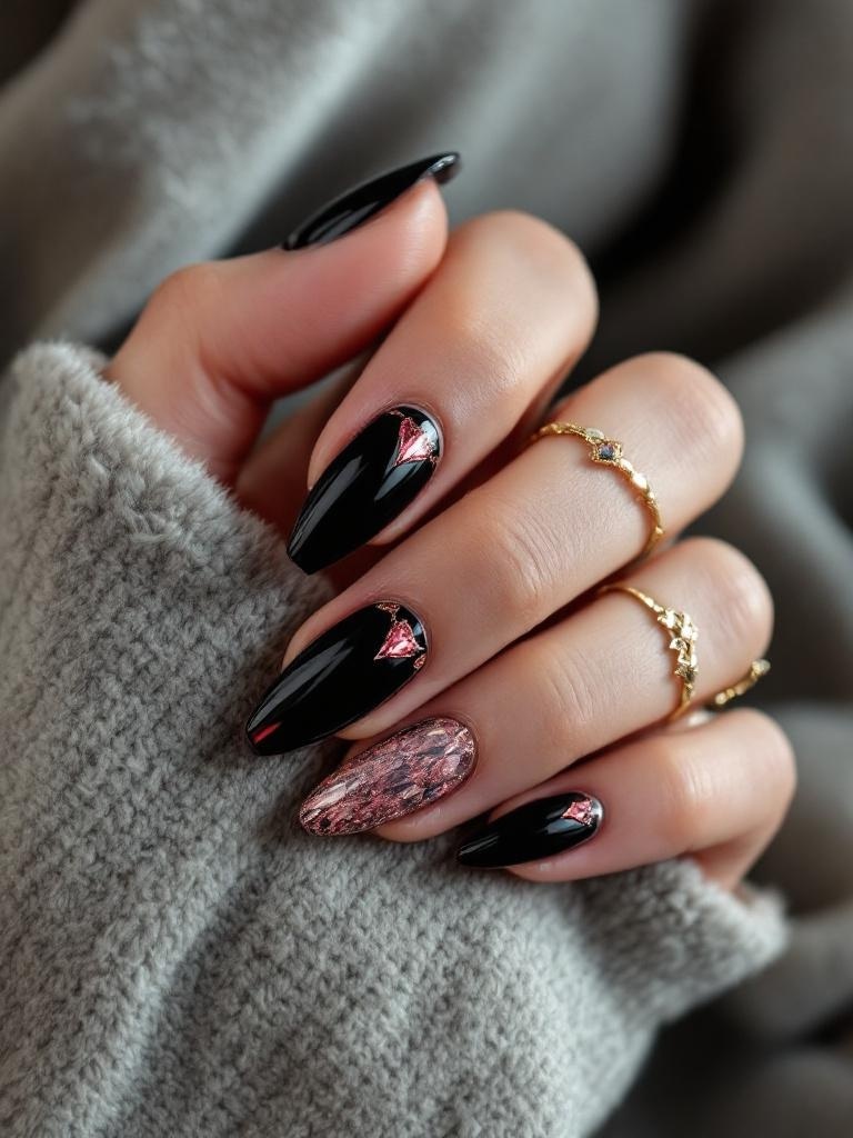 A hand with black nails featuring jewel tone accents and gold rings, resting on a soft gray fabric.