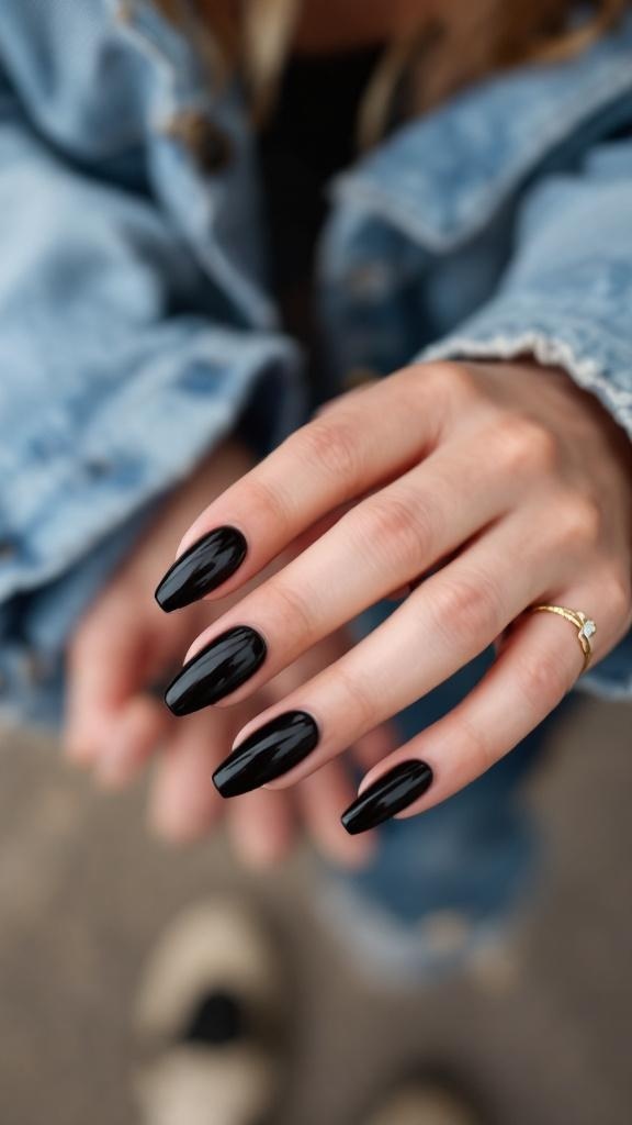 A hand with black stiletto nails and an accent nail, wearing a cozy sweater.