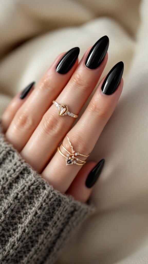 Close-up of black stiletto nails with gold rings on a hand