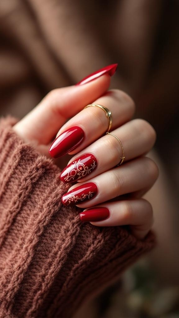 A hand with dark cherry red nails featuring gold designs, holding a knitted brown sweater.
