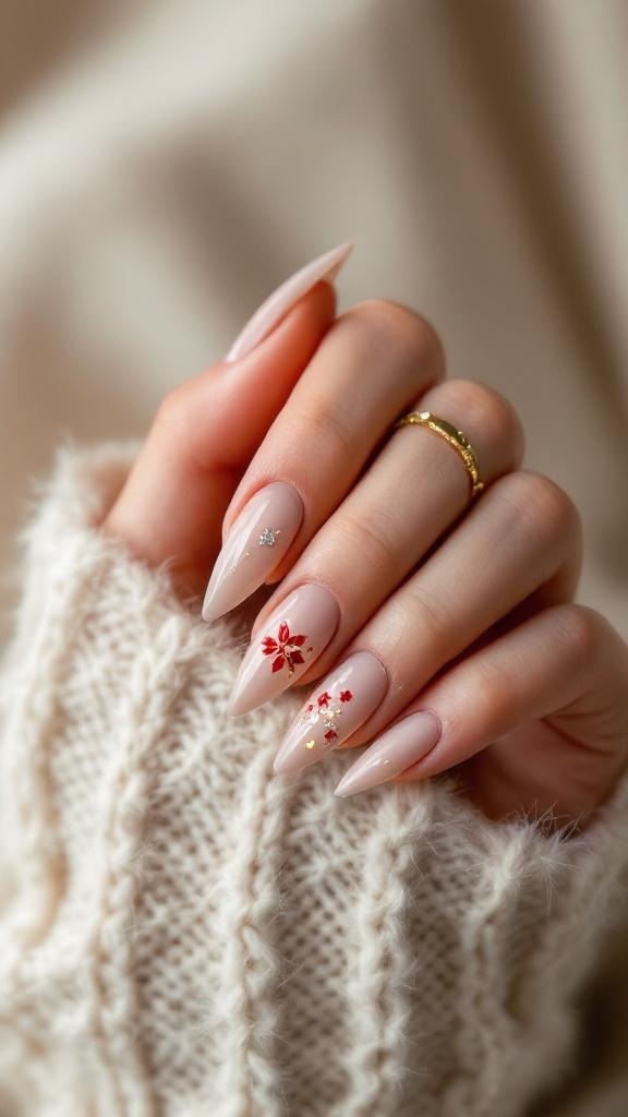 A close-up of beautifully manicured nails with a nude base and red floral designs, adorned with sparkles, resting on a cozy knitted sweater.