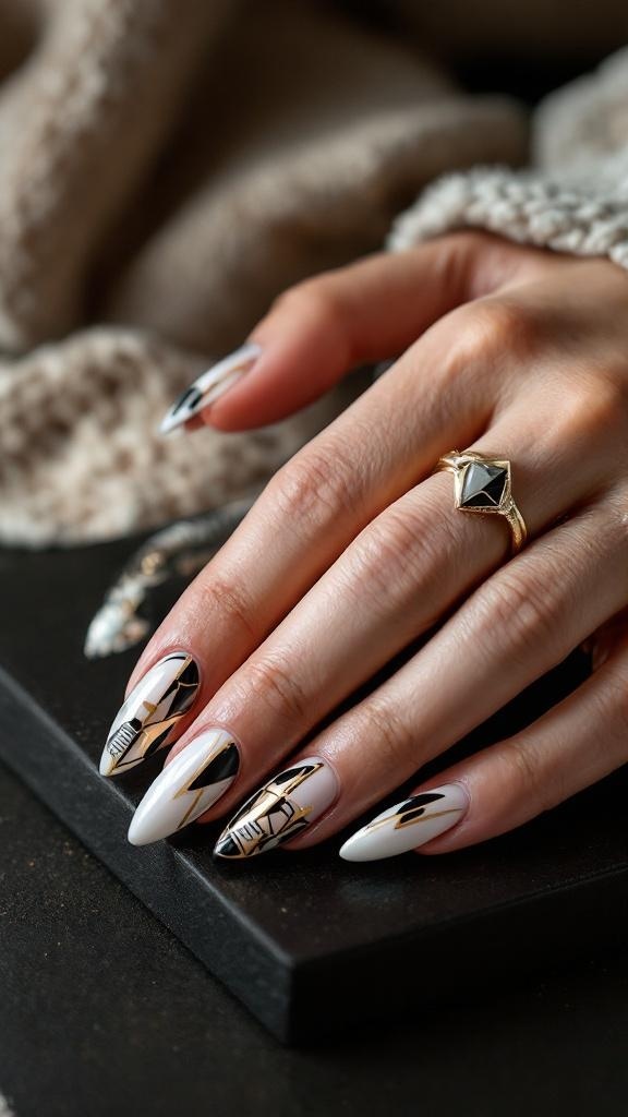 A hand with almond-shaped nails featuring a geometric pattern in black, white, and gold, adorned with a gold ring.
