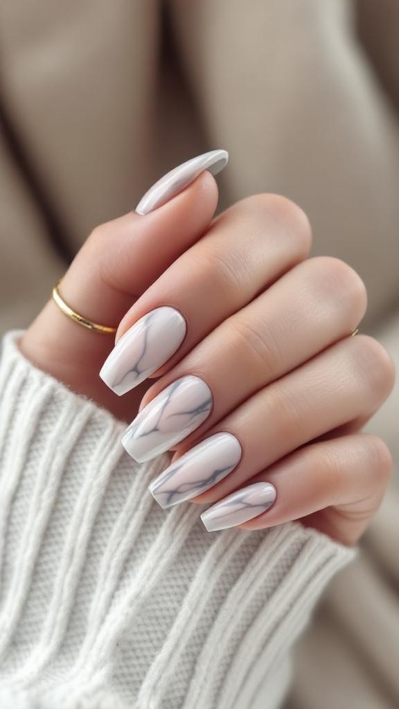 Cute short acrylic nails with a marble effect design in white and gray.