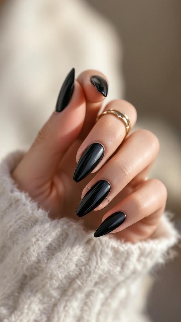 Close-up of black stiletto nails with a glossy finish, showcasing a hand adorned with rings.