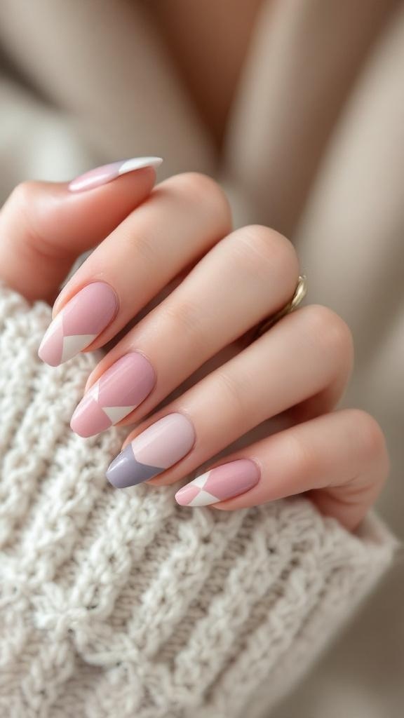 A hand with pastel color block nails featuring shades of pink and purple, resting on a knitted sweater.