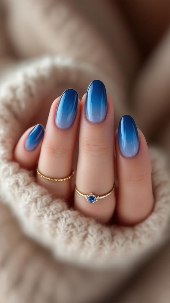 Close-up of hands with blue ombre acrylic nails and gold rings