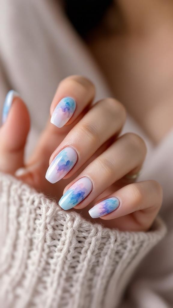 Close-up of whimsical watercolor nails featuring a blend of blue and pink colors.