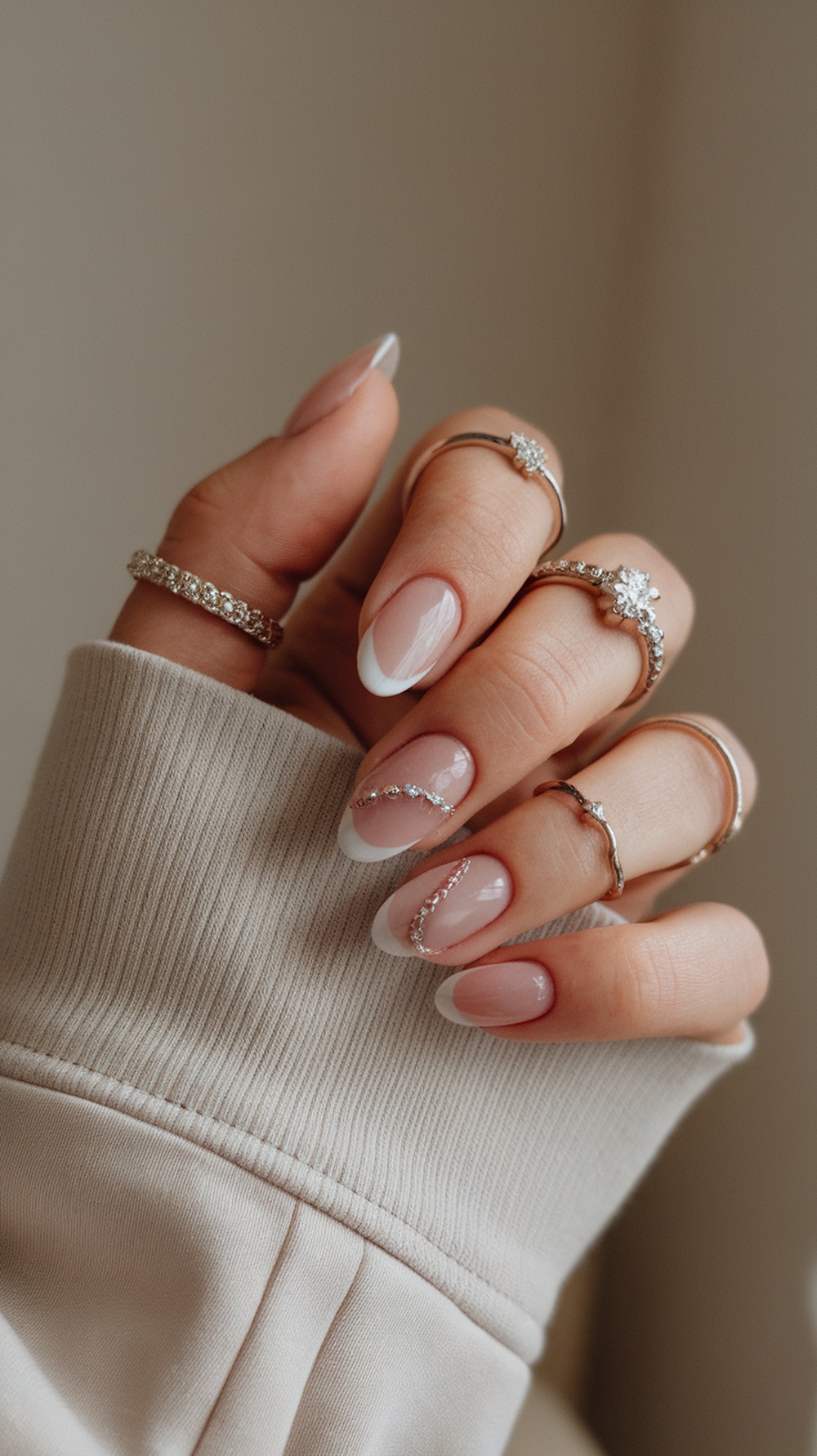 Close-up of bridal nails with glitter accents and rings